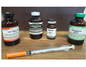 Harmony Hormone Solutions - Four medical vials labeled Lipo-Mino Mix, Tri-Immune Boost, Wesley NAD+, and Glutathione are displayed on a table with a 1mL syringe lying in front of them.